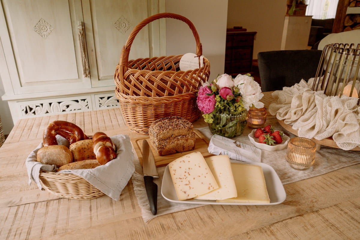 Frühstückskorb mit Brot, Käse und frischen Erdbeeren für die Auszeit am Mika Hof