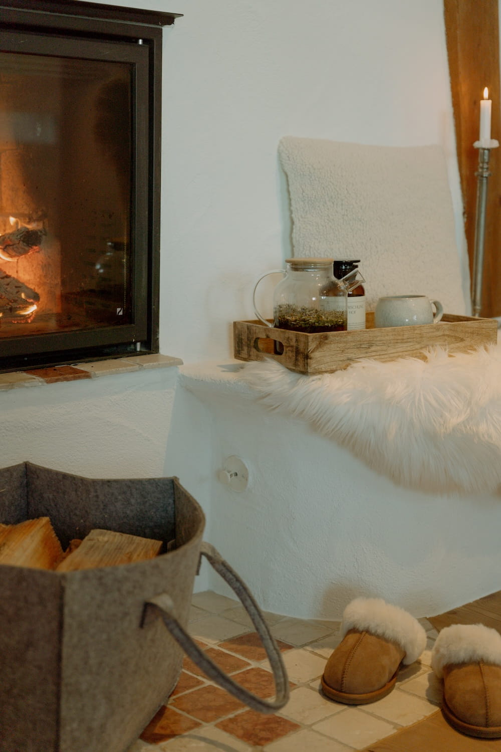 Kamin mit Teekanne, Kerze und Hausschuhen für gemütliche Auszeiten am Mika Hof.