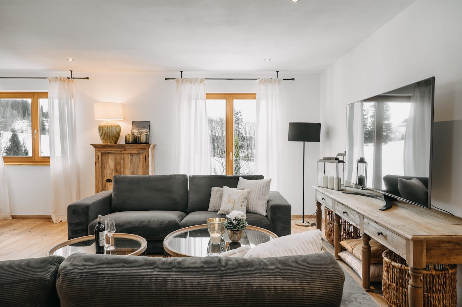 Heller Wohnbereich mit Sofas und Winterblick in der Ferienwohnung Hauchenberg am Mika Hof