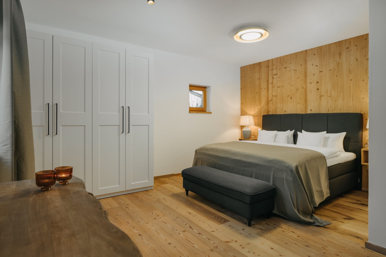 Großzügiges Schlafzimmer mit Doppelbett und Holzwand in der Ferienwohnung Hauchenberg im Allgäu
