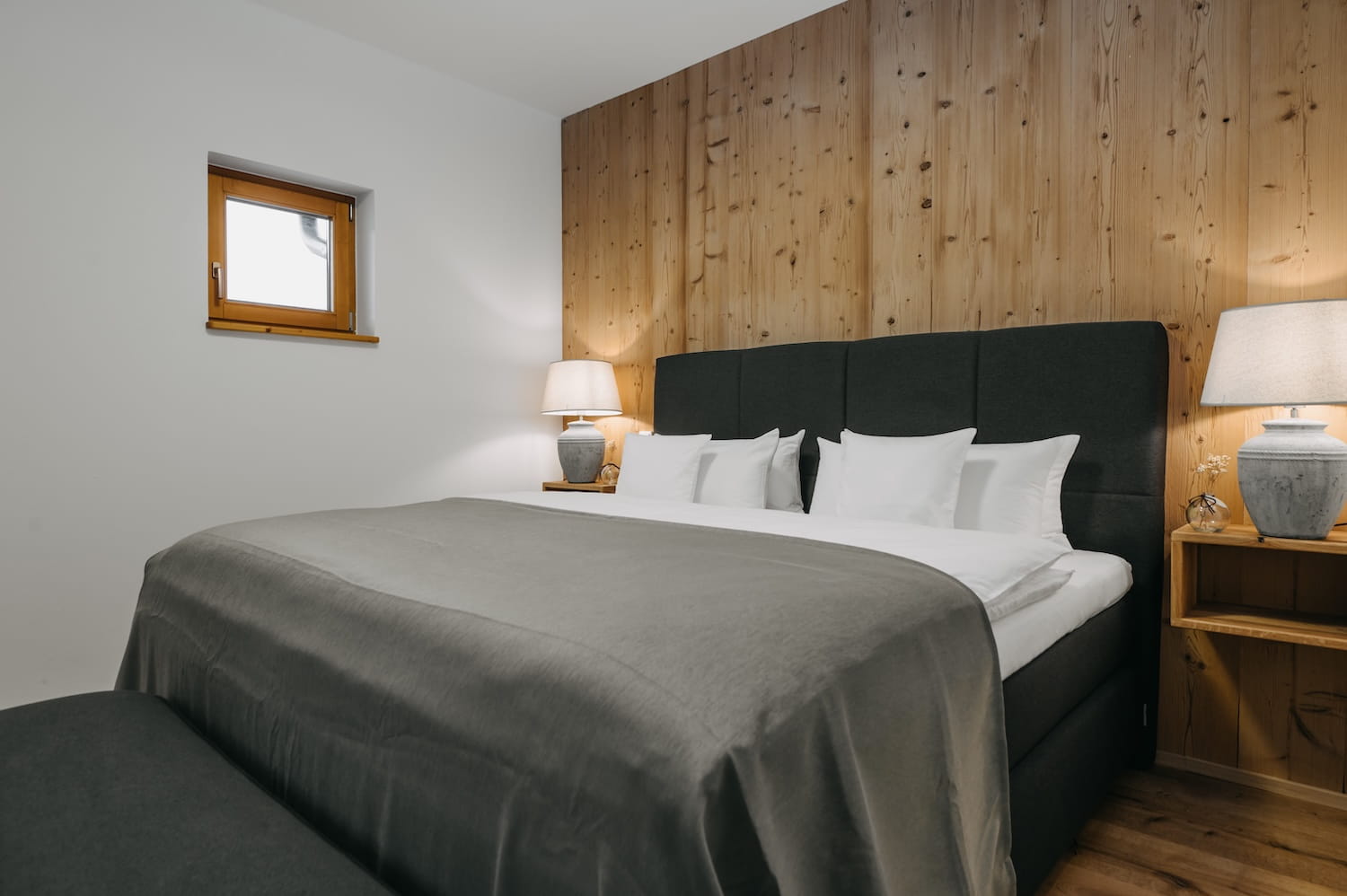 Schlafzimmer mit Doppelbett und Holzwand aus alter Eiche in der Ferienwohnung Hauchenberg