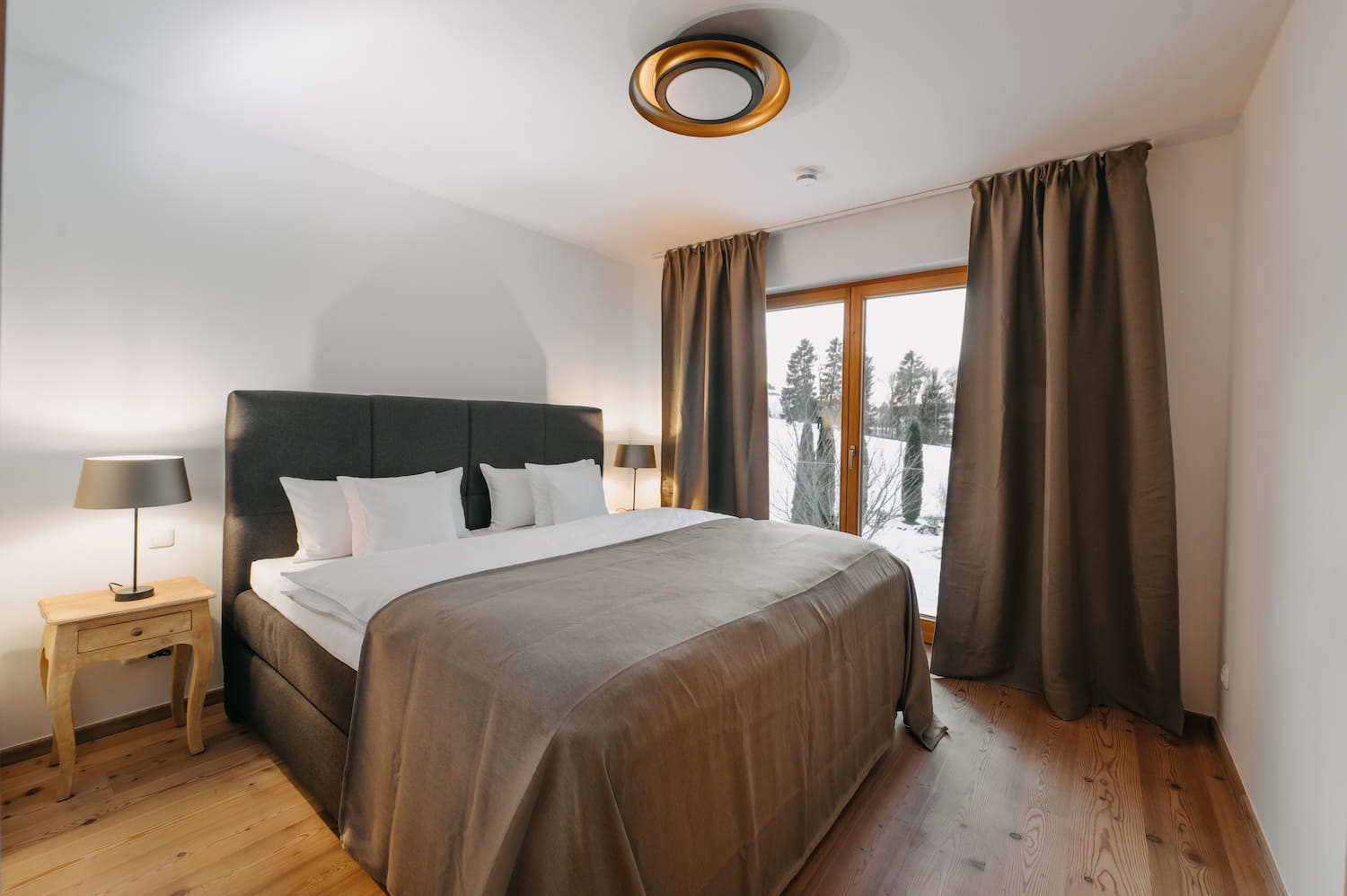 Gemütliches Schlafzimmer im Apartment Hauchenberg mit Doppelbett und Winterblick in die Allgäuer Natur