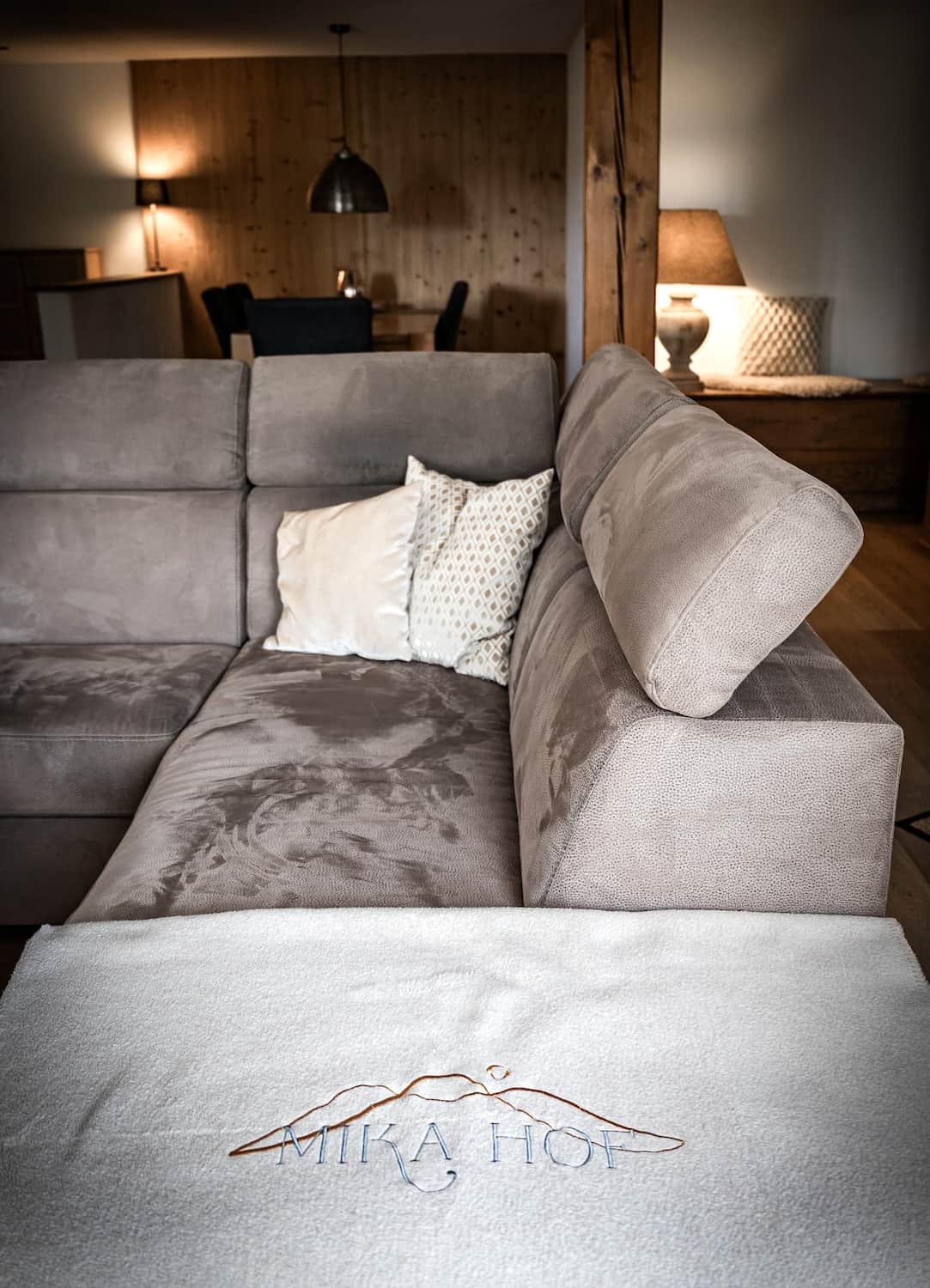 Gemütlicher Wohnbereich mit Sofa und Holzelementen in einer Ferienwohnung am Mika Hof.